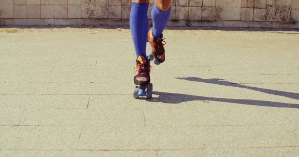 Close Up On Girls Feet While Riding Roller Skates alt