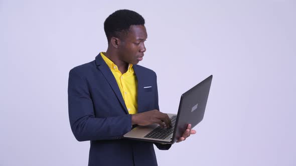Young African Businessman Using Laptop and Looking Shocked alt