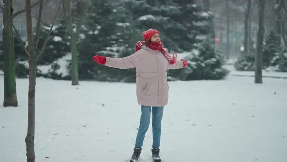 Happy Laughing Woman Walking and Playfully Running in Park at Snowfall Time alt