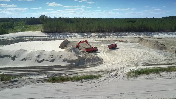 Camera Rises Above Sand Pit with Excavator and Dump Trucks alt