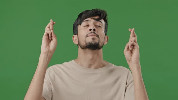 Portrait Arab Indian Hispanic Guy Hopeful Young Man Cross Fingers Praying for Fortune Luck alt