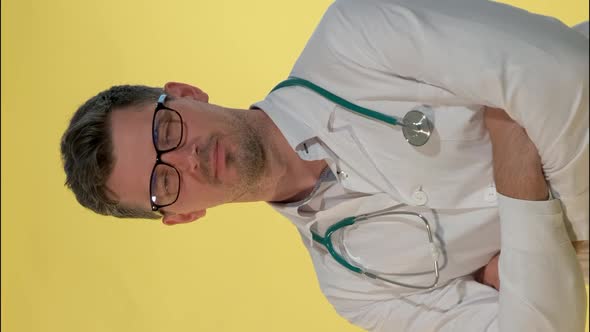 Handsome Doctor in Lab Coat Smiling To the Camera on Yellow Background. alt