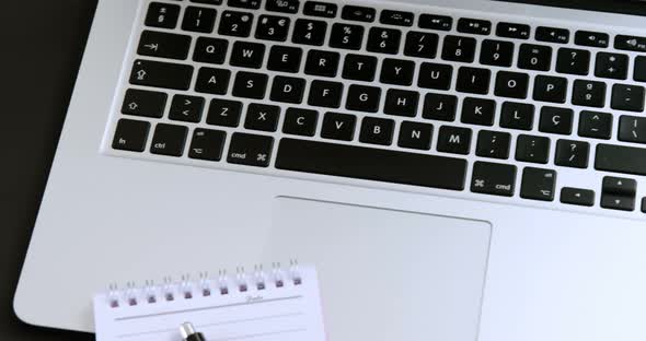 Laptop, notepad, coffee and pen on black background 4k alt