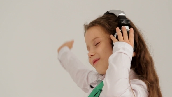 Portrait Of Little Girl In Headphones Listening To