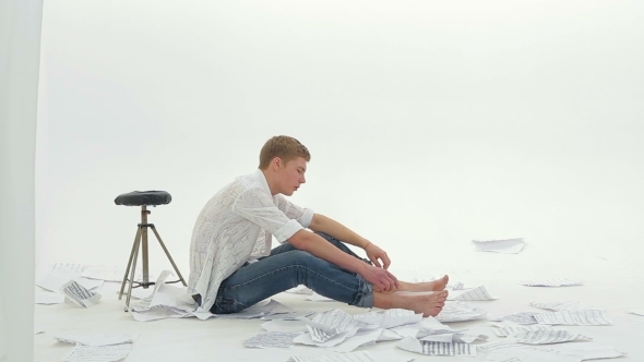 Pensive Young Man Sitting On The Floor And Singing