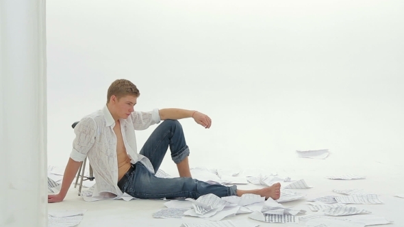 Pensive Young Man Sitting On The Floor