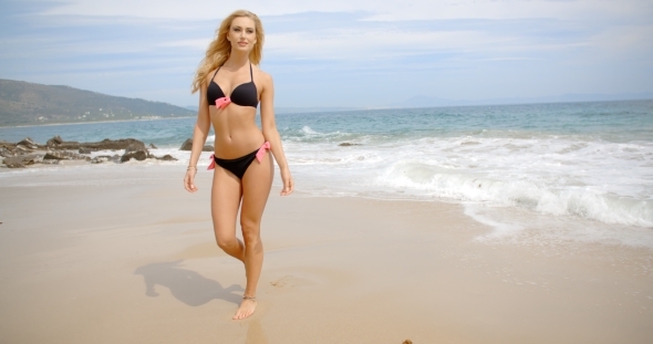 Blond Woman In Black Bikini Walking On Beach alt