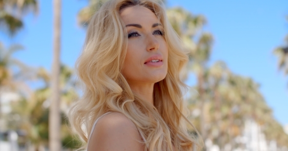 Blond Woman Daydreaming In a Tropical Resort alt
