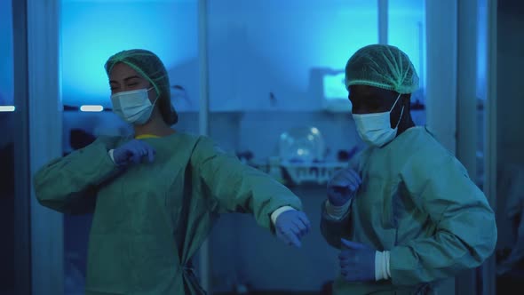 Doctors wearing personal protective equipment having fun dancing in laboratory alt