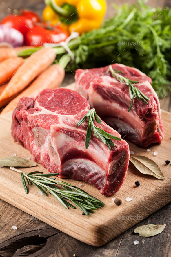 Raw beef meat with bone on cutting board Stock Photo by ff-photo