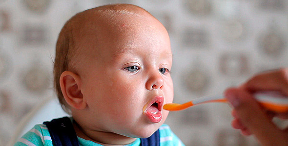 Father Feeds the Child with a Spoon