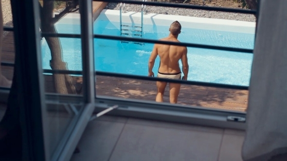 Sexy Confident Man In Swimming Trunks Going On The Pool