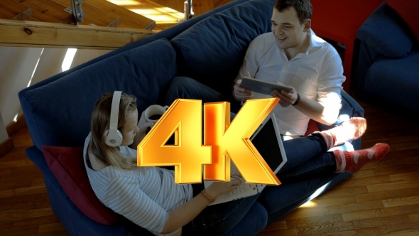 Man And Woman At Home Using Pad And Laptop Man And Woman At Home Using Pad And Laptop