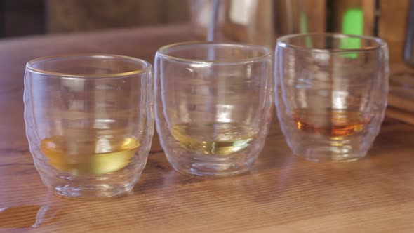 Barista making irish coffee. Pouring water into cups of whiskey.