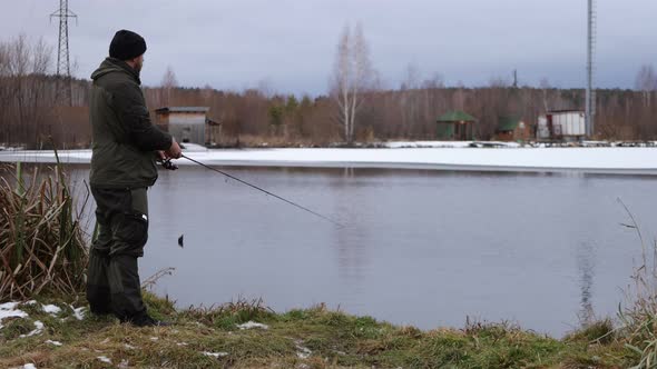 Unrecognizable Man Fishing in Lake at Dawn