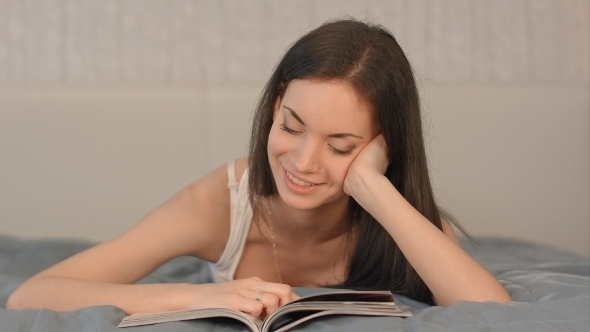 The Girl Reads The Magazine Lying On a Bed The Girl Reads The Magazine Lying On a Bed