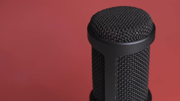 Studio Condenser Microphone Rotates on Red Background with Place for Text alt