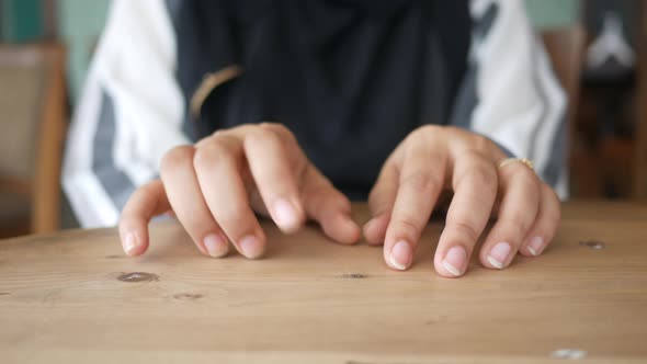 a Nervous Young Women Hand on Table alt