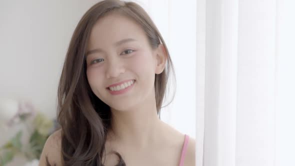 Beautiful closeup portrait young asian woman with smiling and laughing in bedroom. alt