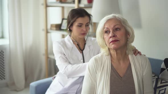 Young Practitioner Is Listening To Adult Patient Using Stethoscope on Woman Back By Slow Motions
