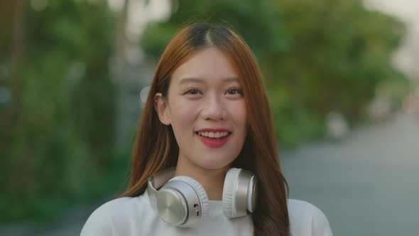 Young Attractive Asian Woman in casual clothes looking at camera and smiling