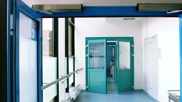 Male doctor talking on mobile phone in passageway of hospital during emergency alt