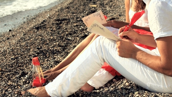 Young Couple Writing Romantic Letters On The Beach Young Couple Writing Romantic Letters On The Beach