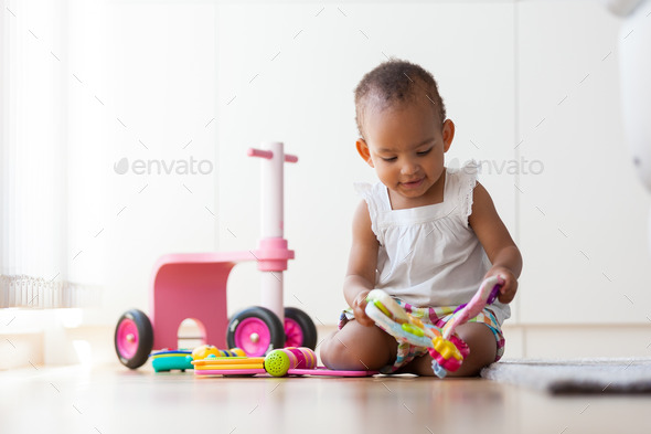 Portrait of little African American little girl sitting on the f - Stock Photo - Images