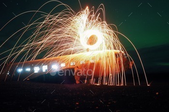 Abandoned DC bomber with steelwool and lights under some northern lights