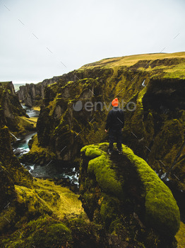 Man standing on a ledge at a green canyon in Iceland