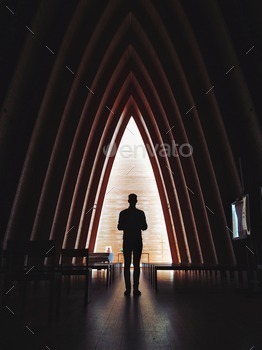 Man in a wooden church silhouetted.