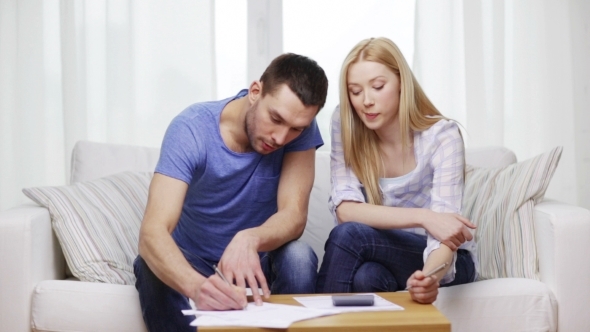 Busy Couple With Papers And Calculator At Home Busy Couple With Papers And Calculator At Home