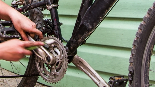Human Hand Cleaning Bicycle Chainring With Brush