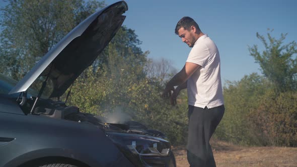 Smoke Under the Hood of a Car Stuck on the Roadside alt
