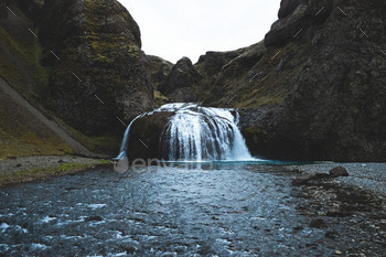 Beautiful waterfall and river in an icelandic green gorge