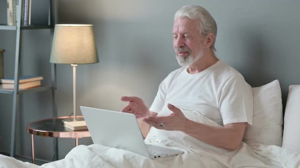 Online Video Call on Laptop By Old Man in Bed alt