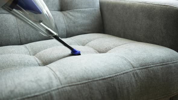 Professional Cleaning of the Sofa from Dust with a Vacuum Cleaner. alt