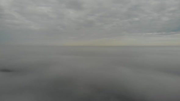 Flying over clouds. Video shot by drone in early morning. Smog above city.