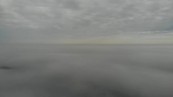 Flying over clouds. Video shot by drone in early morning. Smog above city. alt