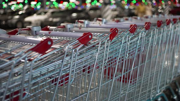 Shopping Carts Stand in an Even Row Near the Car Park in the Mall alt