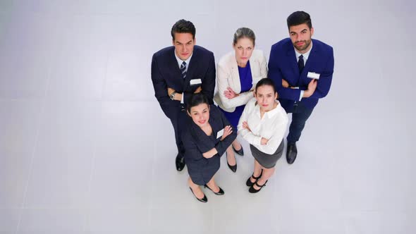 Businesspeople standing with arms crossed in office alt