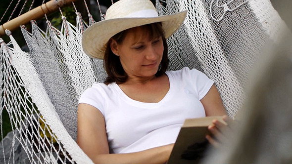 Happy Woman Reading Book In Hammock