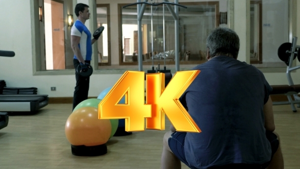 Man Exercising With Weight Disks His Friend Man Exercising With Weight Disks His Friend
