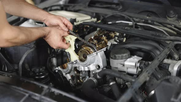 Unrecognizable Mechanic Repairing Automobile Motor Using Tool
