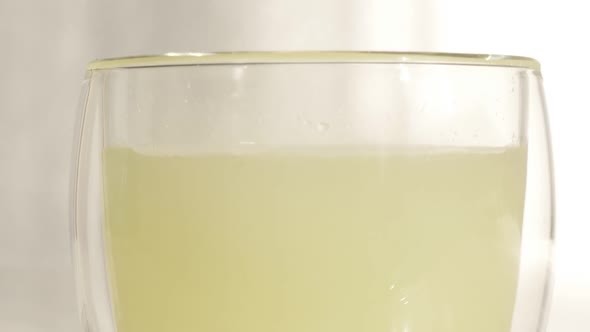 Glass of water and effervescent carbon tablet dissolving alt