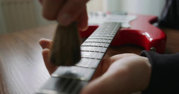 Handmade Guitar Luthier Applying Lemon Oil Cleaner Conditioner On The Guitar Fretboard To Clean And