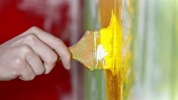 Painting Wall with Yellow Color Paint Using a Brush - Interior Design alt