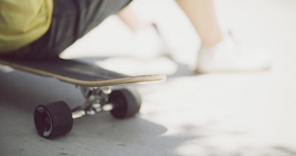 Man Sitting Relaxing On a Skateboard alt
