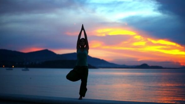 Young Woman Doing Yoga Exercise On The Background