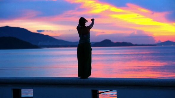 Beautiful Sunset And Young Woman Rising Her Hands